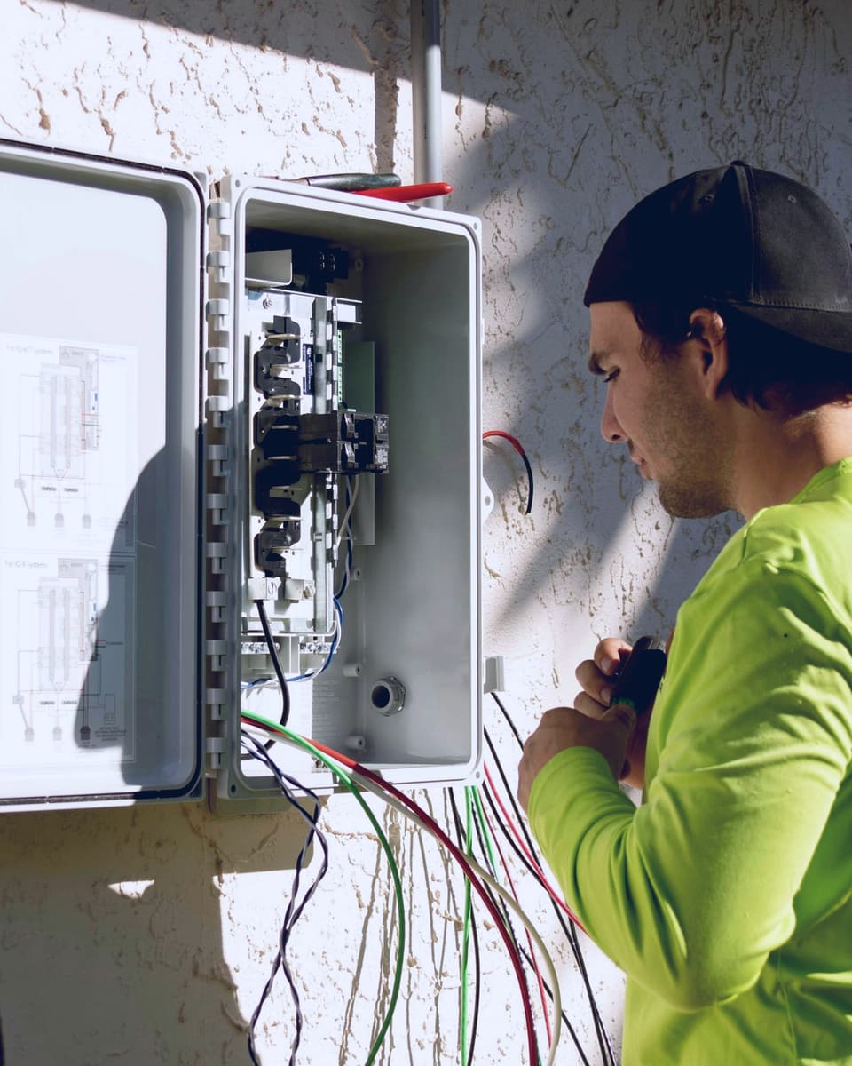 Electrician wiring a set of outdoor electrical panels