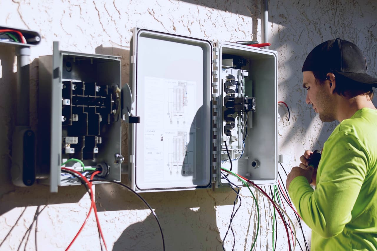 Electrician working between two open electrical panels